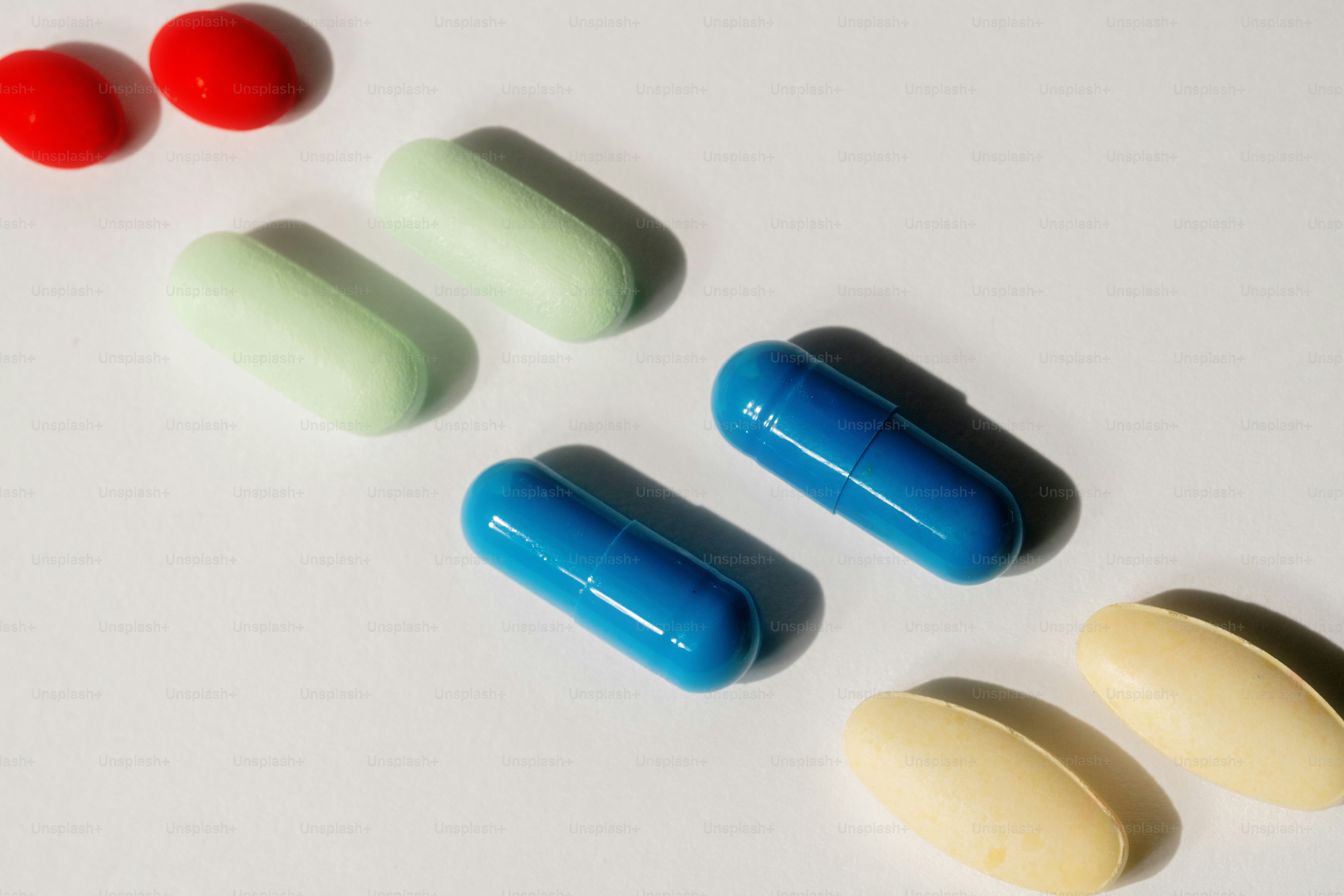 Pills and capsules of various colors are shown